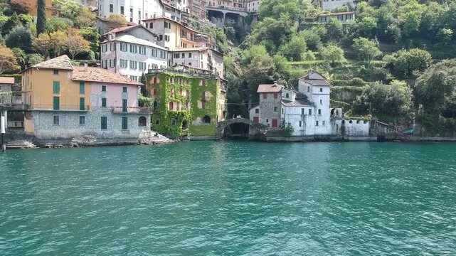 Drone panorama of Nesso on Lake Como, Italy, with waterfront homes, waterfall and alpine slopes