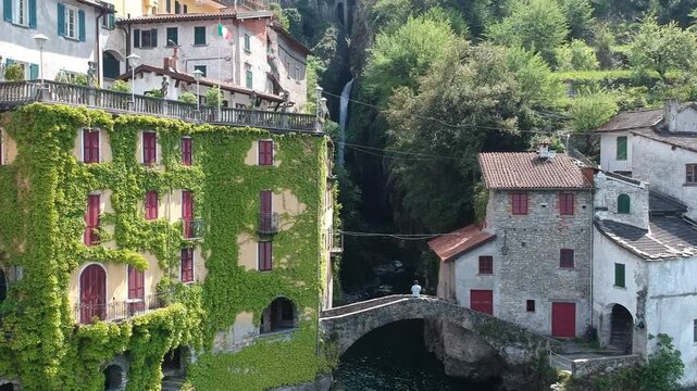 Nesso waterfall and Ponte della Civera drone view on Lake Como, Italy, beside historic homes