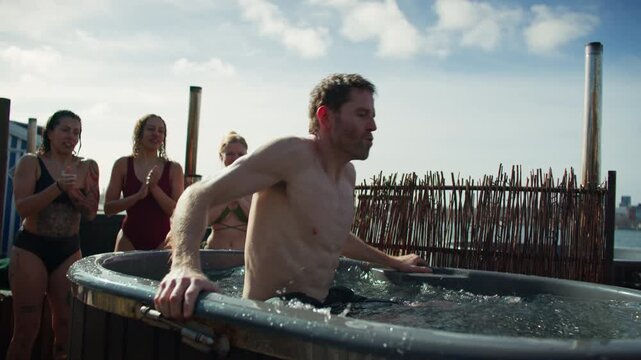 Friends cheering during outdoor cold plunge challenge and social wellness recovery session