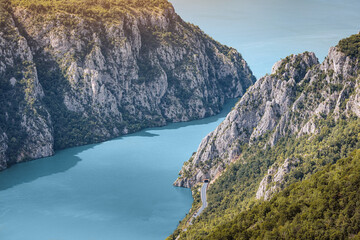 Fototapeta premium Danube River flowing through a deep gorge with steep, forested cliffs and a road following the winding banks in summer