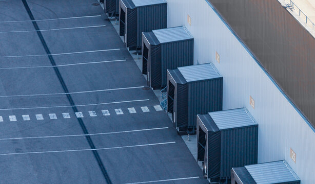 Aerial view of empty warehouse loading docks with numbered truck bays, showing logistics infrastructure and commercial freight handling in Le Pouzin, Auvergne-Rhone-Alpes, France.