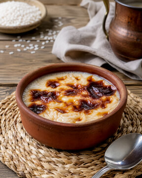 Baked rice pudding with caramelized topping, served in an earthenware bowl, is a traditional Turkish dessert.