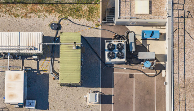 Aerial view of industrial cooling equipment, pipes, pumps, processing units and technical machinery at a biogas and renewable energy facility, Le Pouzin, Auvergne-Rhone-Alpes, France.