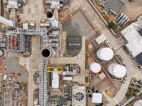 Aerial view of Parque Electrico Los Mina power plant with industrial chimneys, storage tanks, pipe networks, and paved infrastructure in Santo Domingo, Santo Domingo, Dominican Republic.
