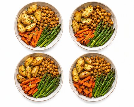 Four bowls of healthy roasted vegetables isolated on white background