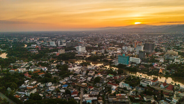 Aerial view of the Ping River winding through the urban landscape at sunset, Chiang Mai, Thailand.