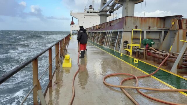 crew members washing vessel at sea.