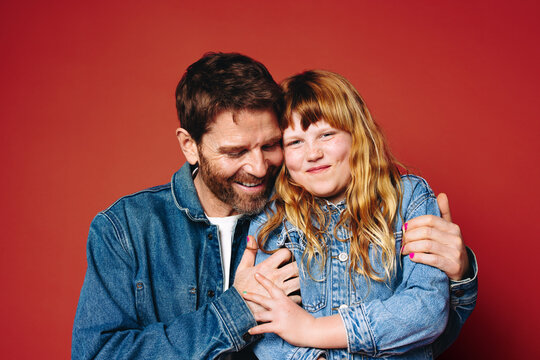 Father and daughter hugging in studio portrait with happy family love and close bond