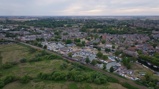 Aerial Follow shot of Greater anglia train in front of Ely cathedral