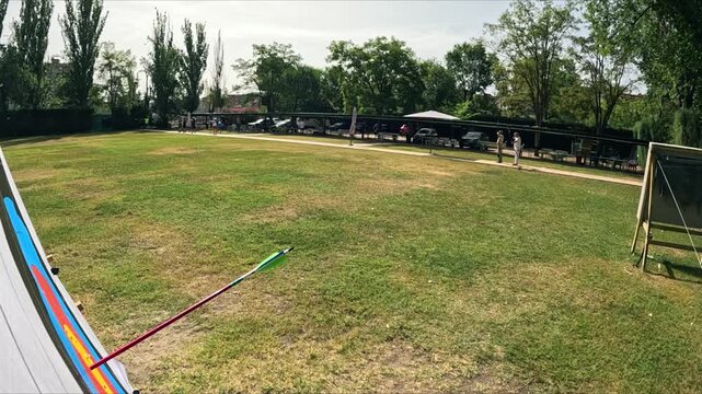 First person perspective of an archer training at an outdoor range. Arrows flying and hitting the target with precision during a competition