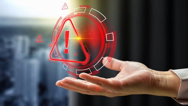 Glowing red digital warning hologram floating above a businesswoman hand, representing system error, cybersecurity risk, and hazard alert. Cyber threat concept