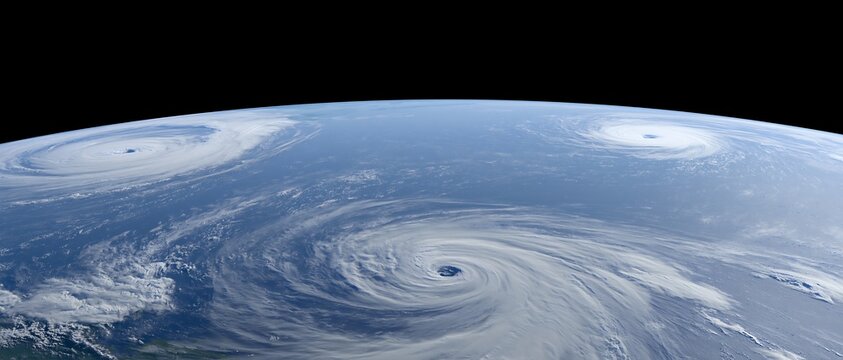 Three tropical cyclones active over the ocean at the same time viewed from space, illustrating compound weather events, storm season, forecasting, climate risk and emergency preparedness