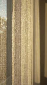 Sheer curtains softly illuminated by sunlight, creating a warm ambiance in a cozy indoor setting with visible textures and patterns enhancing the atmosphere