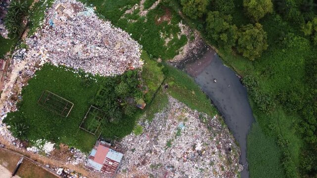 Aerial view of a waste landfill situated along a dense vegetation in the urban landscape of Ogun State, Nigeria. 