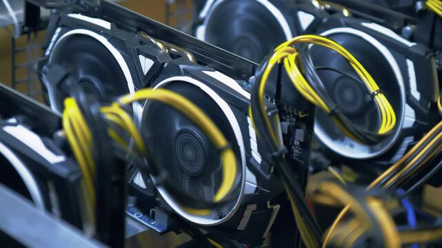 Working graphics cards form a diagonal cluster with rotating dual fans while yellow PCIe cables loop across the foreground of an open frame GPU mining rig