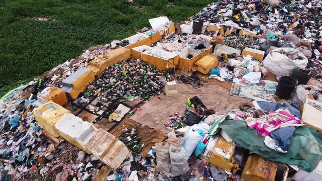 Aerial view of a large waste landfill situated along a dense vegetation in the urban landscape of Ogun State, Nigeria. 