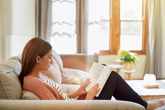 Relax, woman and reading a book on sofa for literature hobby, knowledge or story chapter on fantasy. Reader, calm person and literary novel in home for fiction bestseller, vocabulary or weekend break