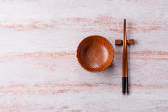 An empty round wooden plate on a textured background. An empty round plate