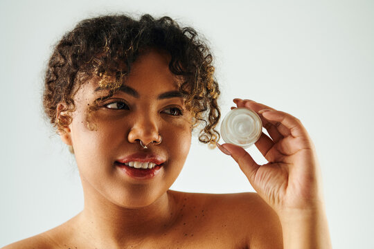 Confident young woman enjoying self care with a beauty product