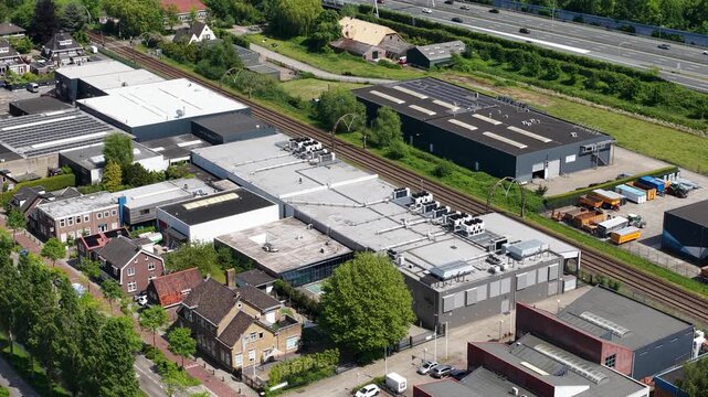 Aerial view of modern industrial zone with railway tracks and highway traffic in netherlands.