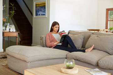 Fototapeta premium Woman, reading and book at house with coffee, fiction story and comfortable for literature. Female person, unwind and beverage in lounge with novel, fantasy storytelling and poetry for stress relief