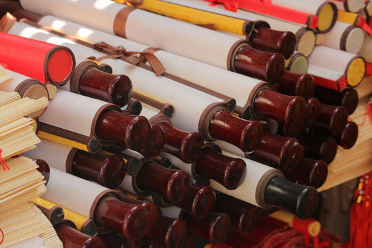 A large stack of traditional blank paper scrolls with wooden handles on a market display, Ho Chi Minh City, Vietnam.