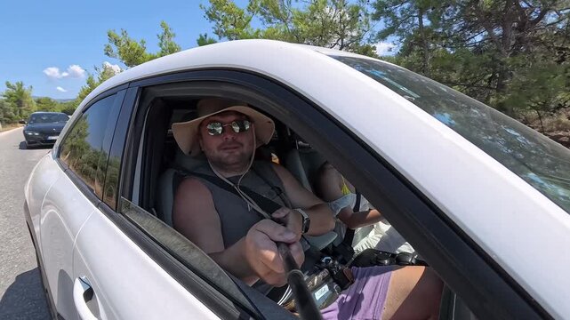 Male Tourist Recording Travel Vlog From Car Window