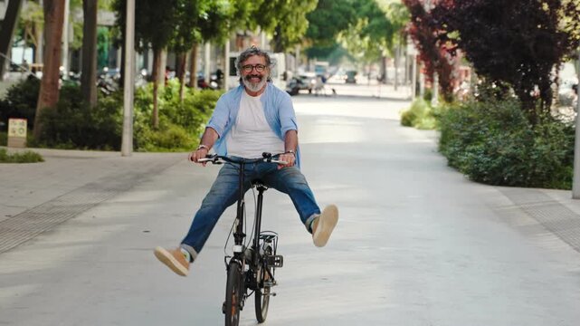 Senior man riding bicycle in urban city having fun during active lifestyle. Happiness, vitality and retirement