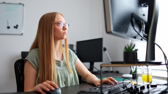 Young woman working on computer at modern office