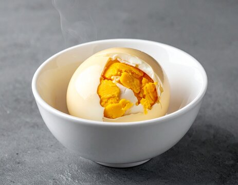 Balut boiled duck egg delicacy.Exotic authentic balut egg served in a white bowl, revealing the rich yolk interior of this traditional street food.
