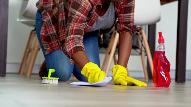 Woman cleaning floor with rag and detergent