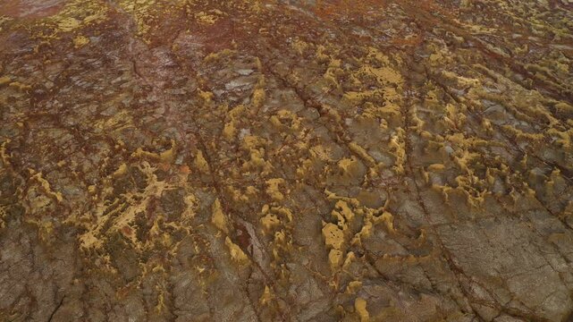 Aerial view of the colorful mineral formations and rugged salt crusts of the geothermal area in Dalol, Afar, Ethiopia.