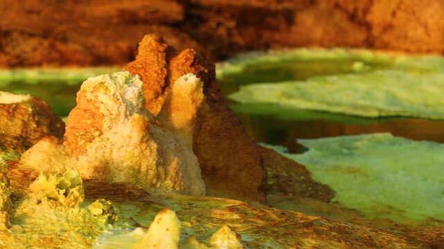 Aerial view of vibrant mineral deposits and bubbling geothermal pools in the volcanic landscape of Dalol, Afar, Ethiopia.