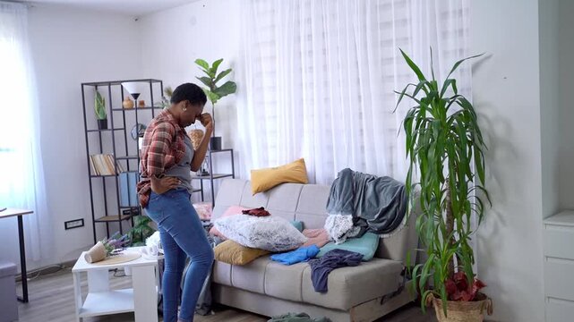 Young woman dancing in messy living room