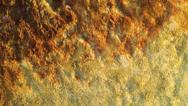 Aerial view of the vibrant yellow and orange mineral deposits of the Dalol geothermal area with textured salt formations in Dalol, Afar, Ethiopia.