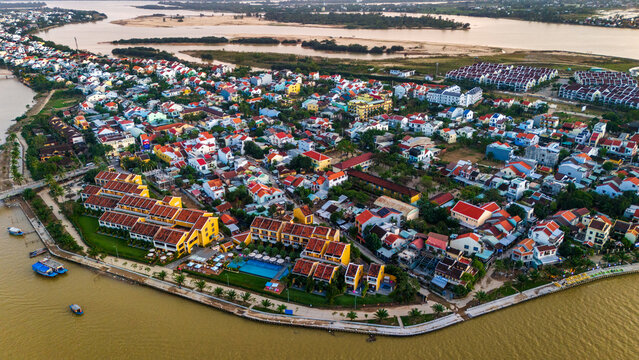 Aerial view of Hoi An ancient town featuring traditional yellow buildings, tiled roofs, and riverfront scenery in Hoi An, Da Nang, Vietnam.