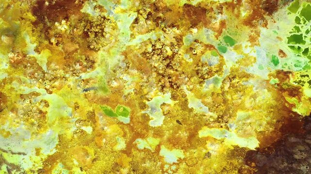 Aerial view of the vibrant yellow and orange mineral deposits and hydrothermal salt formations at the Dallol geothermal area in Dalol, Afar, Ethiopia.