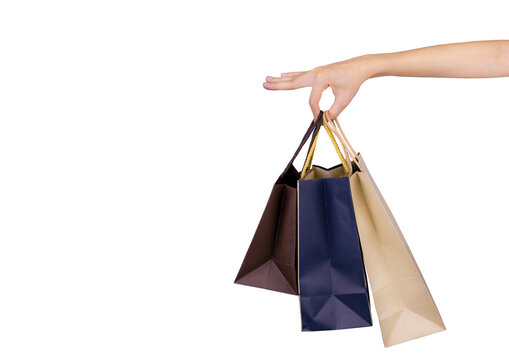 Woman carrying blue and brown paper shopping bags isolated on white background, representing consumer spending, retail purchasing, customer lifestyle, seasonal sales and Black Friday shopping concept.