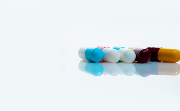 Antibiotic capsule pills on white background. Prescription drugs. Colorful capsule pills. Antibiotic drug resistance concept. Pharmaceutical industry. Superbug problems. Medicament and pharmacology.