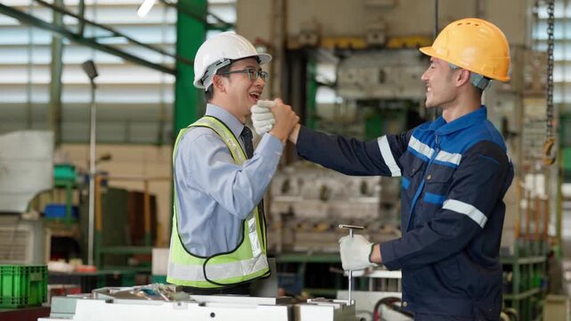 Industrial engineer and factory worker communicate beside machinery in a manufacturing facility, representing teamwork, leadership, technical discussion, and workplace collaboration.