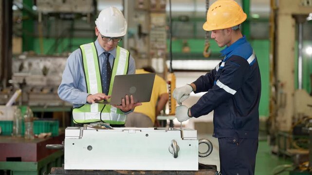Industrial engineer and factory worker review information together beside machinery, representing teamwork, technical communication, production management, and industrial collaboration.