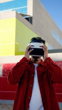 Moroccan man holding a virtual reality headset, stepping into the metaverse with modern technology in an urban setting