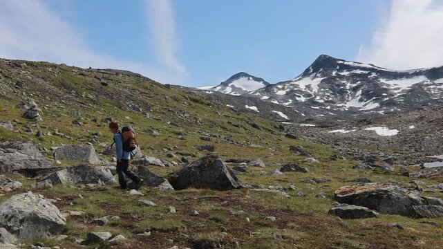 Beautiful european family with children and pet dog, hiking Kyrkja mountain on a beautiful sunny summer day, sunset, snow, lakes, valley