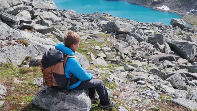 Beautiful european family with children and pet dog, hiking Kyrkja mountain on a beautiful sunny summer day, sunset, snow, lakes, valley