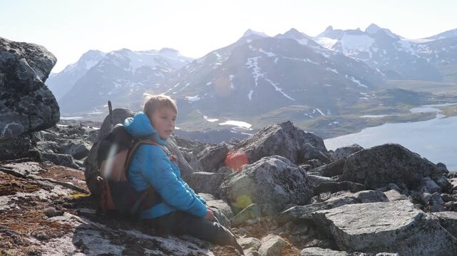 Beautiful european family with children and pet dog, hiking Kyrkja mountain on a beautiful sunny summer day, sunset, snow, lakes, valley