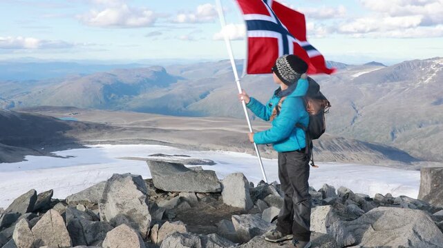 Beautiful european family with children and pet dog, hiking Galdhoppigen, 2469 m, the highest mountain peak in Norway on a beautiful sunny summer day, sunset, snow