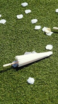 Stylish white vintage umbrellas provide shade from the hot, bright sun on a sunny summer day. Wedding ceremony for the bride and groom.