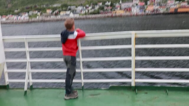 European family, kid with pet dog, enjoying ferry ride between Senja and Andenes Andoya summertime, child and adults on a ferry on sunset