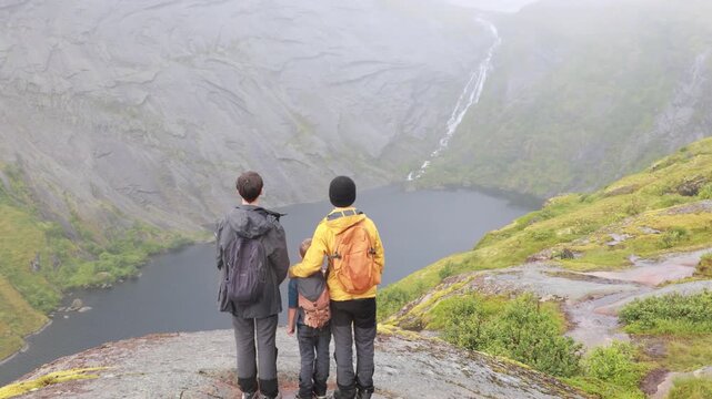 Mother with three kids and a pet dog, hiking Munkebu in extremely bad weather, fog and rain, andventure hiking in nature in Lofoten, Norway