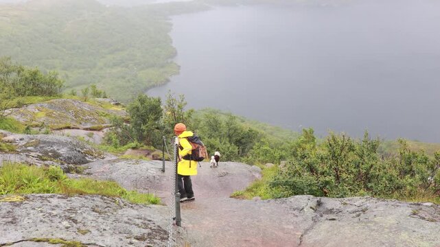 Mother with three kids and a pet dog, hiking Munkebu in extremely bad weather, fog and rain, andventure hiking in nature in Lofoten, Norway